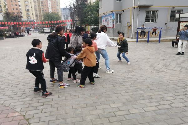 0a1016a2f7124a9c919b0dfb3cfa1e90.jpg 小老师与同学们进行室外游戏.jpg