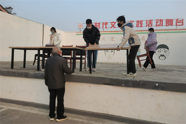 4c8af16d50ca40e28975123b33b0cd6d.jpg 志愿者帮忙布置会场.jpg